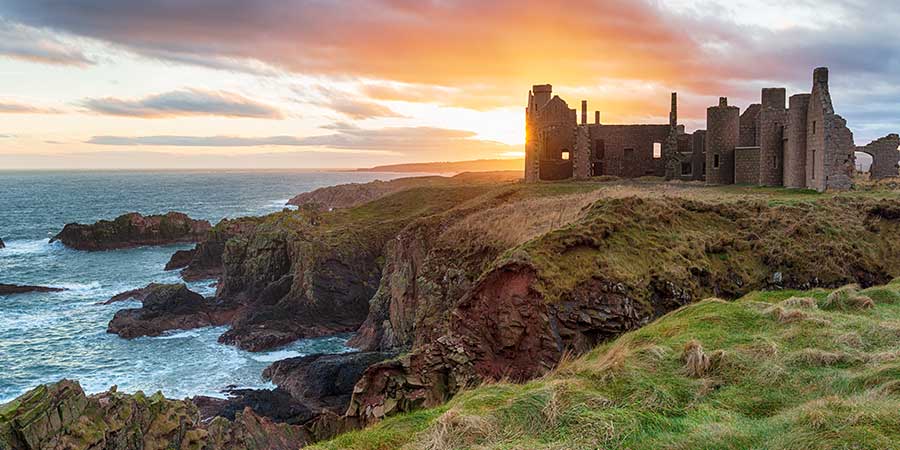 Castle at sunrise on coast of Scotland