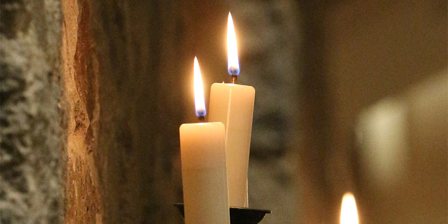 Candles on wall of church from the cover of the Lenten Meditation Guide