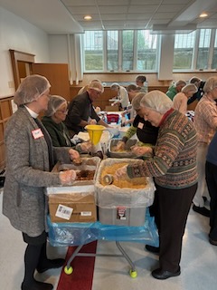 Volunteers from St. Andrews pack meals together.