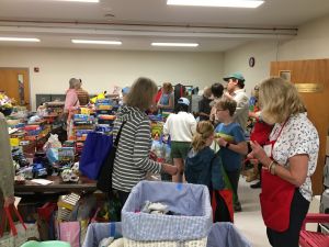 People attend an indoor bargain haul shopping for toys.